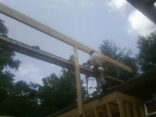 Carpenter setting a ridge beam over a new addition frame — Ice Dam Removal by Roofing Brothers in Upper Darby