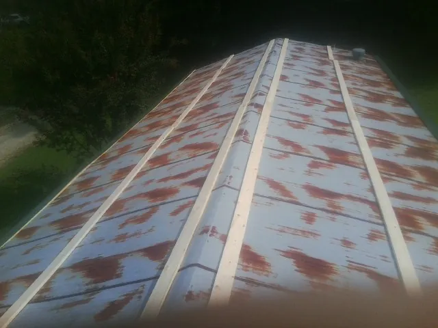 Rusted metal roof panels with new wood purlins before replacement — Storm Damage Roof Repair in Upper Darby by Roofing Brothers