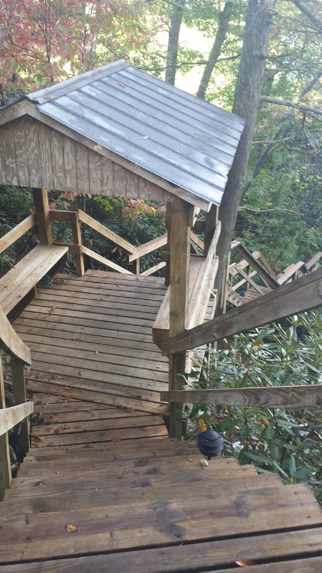 Metal roofed shelter over wooden steps on a wooded walkway — Skylight Repair & Installation work by our crew in Upper Darby