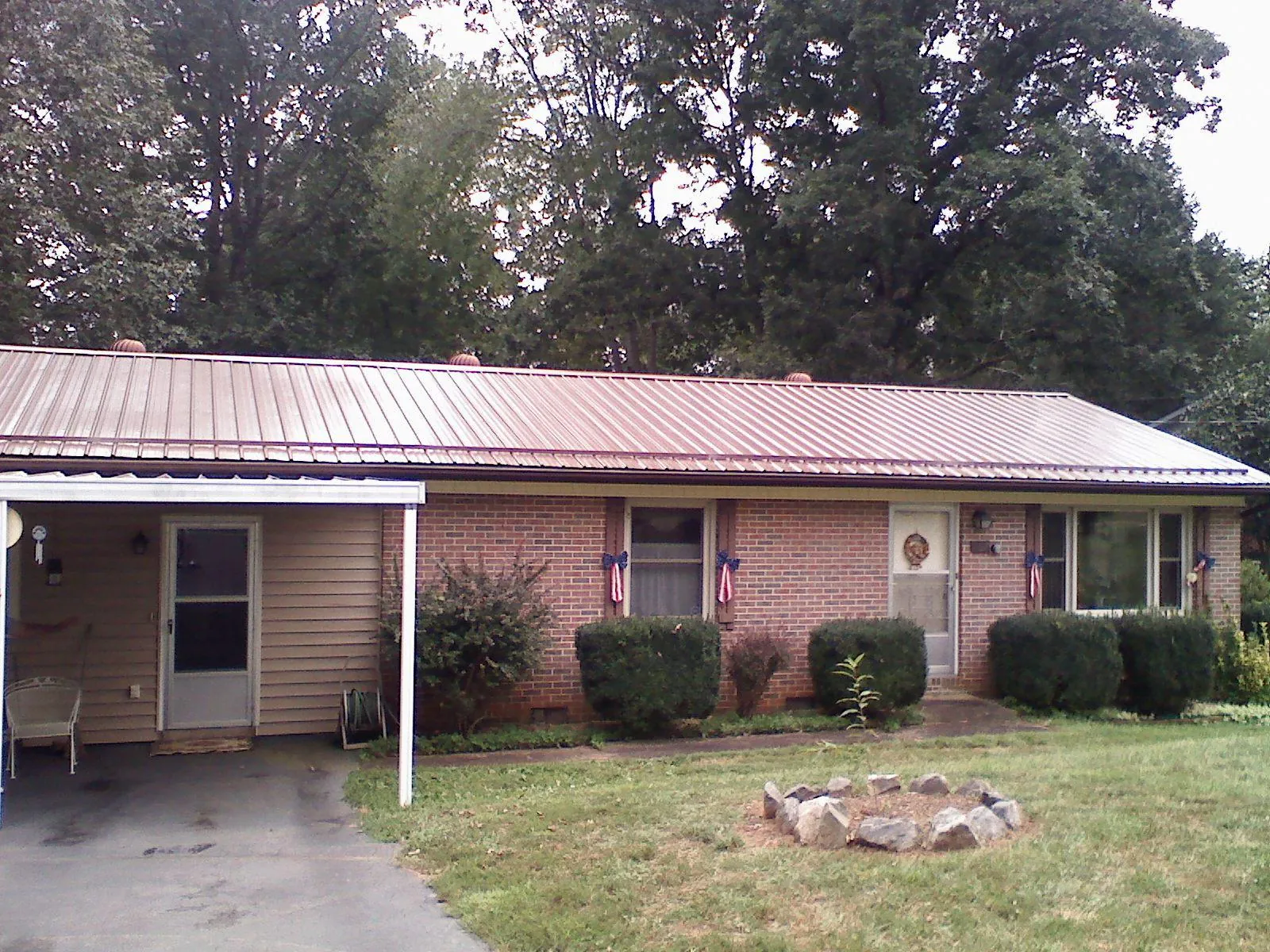 Bronze metal roof and carport on a brick ranch home — Roof Repair work by our crew in Upper Darby